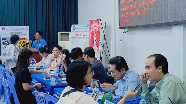 Người lao động đang tìm hiểu thông tin tuyển dụng tại phiên giao dịch việc làm - Ảnh 1.