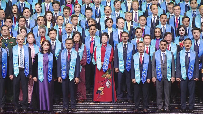 Toàn cảnh hàng đại biểu trong trang phục trang trọng, đeo dải băng xanh trên sân khấu. - Ảnh 1.