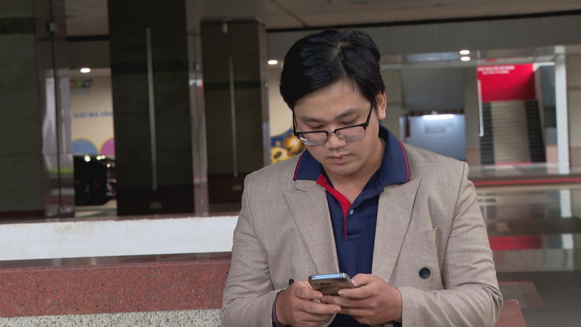 Anh Lý Hữu Quân sử dụng điện thoại khi trao đổi về việc nhận diện và kiểm chứng tin giả do AI tạo ra.- Ảnh 1.