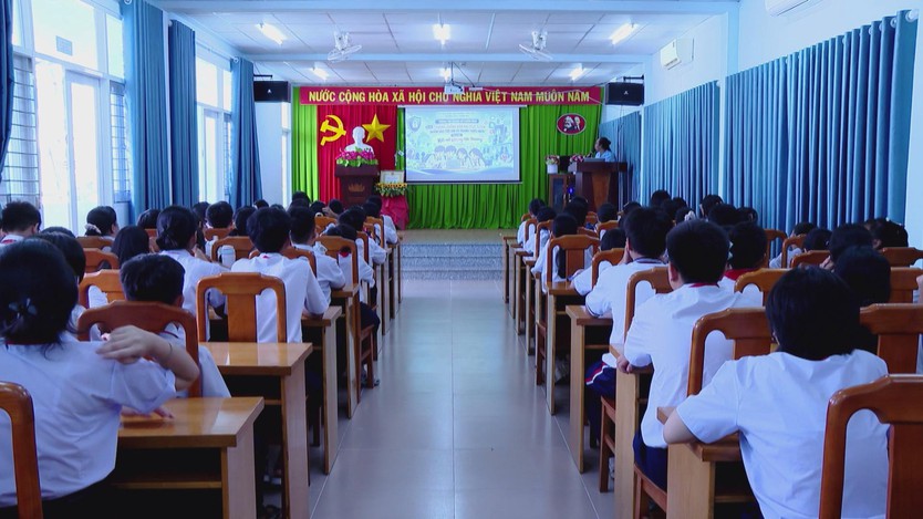 Học sinh ngồi kín các dãy bàn trong hội trường theo dõi màn hình trình chiếu bài giảng về kỹ năng an toàn trên không gian mạng - Ảnh 2.