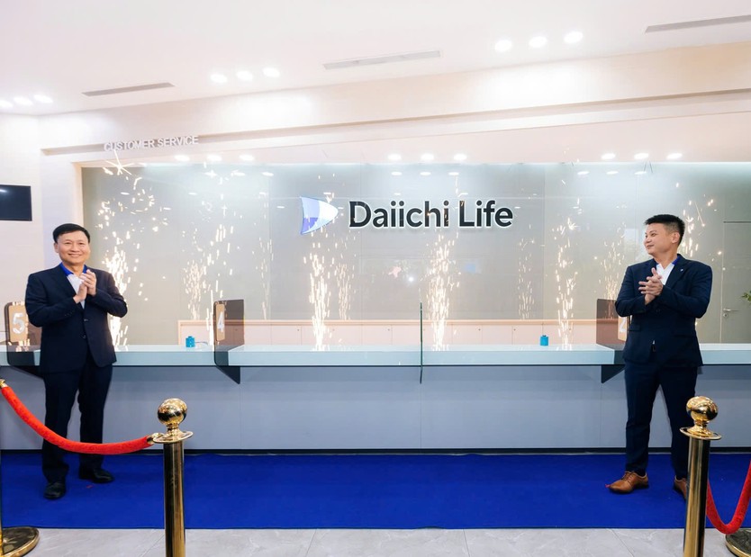 Hai người đàn ông mặc vest đang đứng vỗ tay trước quầy dịch vụ khách hàng có logo Dai-ichi Life mới, xung quanh là pháo sáng chúc mừng - Ảnh 3.