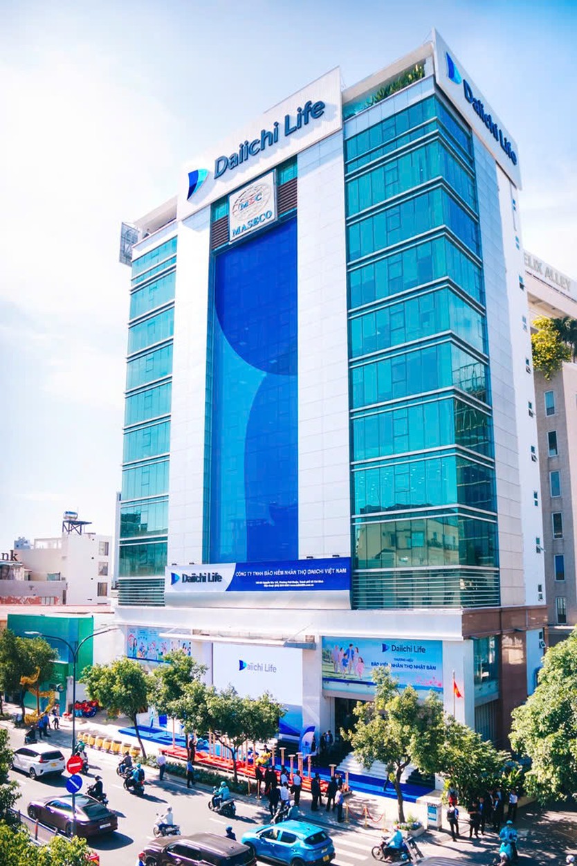 Tòa nhà cao tầng mặt kính xanh lá cây với bảng hiệu logo Dai-ichi Life mới nổi bật trên đỉnh và ở tầng trệt, nằm trên đường phố tấp nập xe cộ - Ảnh 4.