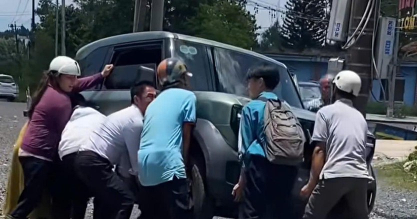 Người dân nâng ô tô cứu bé gái mắc kẹt dưới gầm ô tô - Ảnh 1.