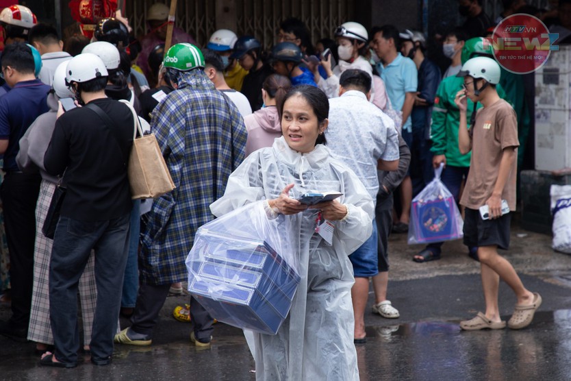 Tiệm tăng giá bánh trung thu, khách vẫn đội mưa chờ đến lượt - Ảnh 7.