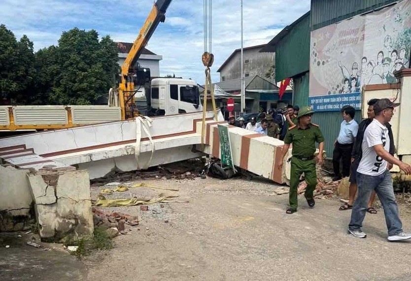 Xe tải cẩu kéo đổ cổng chào, đè phải bé trai học lớp 3 - Ảnh 1.