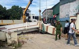 Xe tải cẩu kéo đổ cổng chào, đè phải bé trai học lớp 3