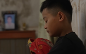 Em Đức Thiện ôm chặt chiếc cặp cũ để nguôi nỗi nhớ mẹ